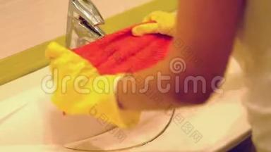 慢动作。 女人在家里的浴室里做家务，用喷雾洗涤剂清洗水槽和水龙头。 封闭的视野